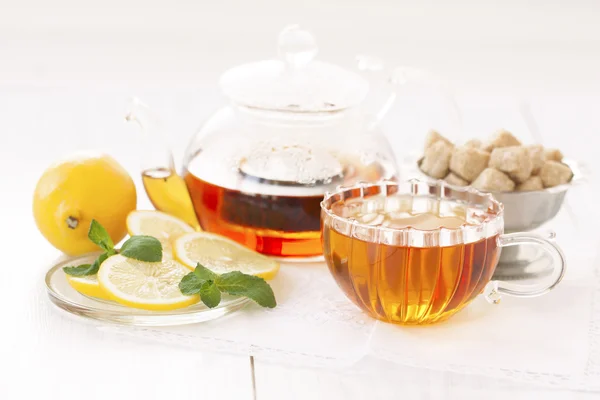 Hrnek horkého čaje čaje, cukr a citron na světlém pozadí — Stock fotografie