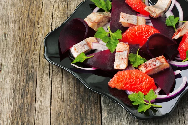 Prato com uma salada de arenque, beterraba e toranja — Fotografia de Stock