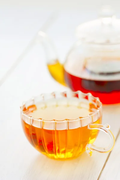 Šálek horkého čaje konvice na stole — Stock fotografie