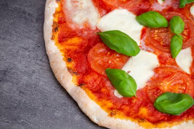 Koyu arka planda pizza margherita. Geleneksel İtalyan pizzası, en iyi manzara. Paket yemek.