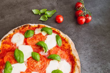 Koyu arka planda pizza margherita. Geleneksel İtalyan pizzası, en iyi manzara. Paket yemek.