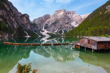 Dolomitler, Unesco Dünya Mirası, Güney Tyrol, İtalya 'daki Pragser Wildsee (Lago di Braies) ikonik dağ gölünün berrak sularında yansıyan kayıkhane ve Seekofel Dağı panoramik manzarası