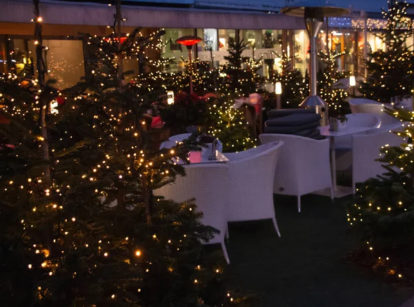 restaurant terrace decorated with christmas trees lights near traditional famous christmas market (christkindlmarkt) at Merano, South Tyrol/Italy