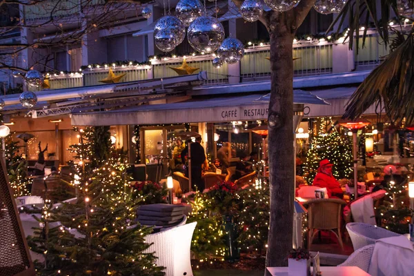 Merano, Güney Tyrol / İtalya 'daki geleneksel ünlü noel pazarının (Christkindlmarkt) yanında yılbaşı ağaçlarıyla süslenmiş restoran terası.