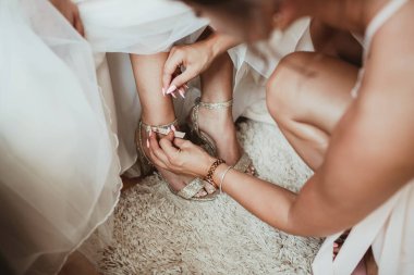 Düğün günü, geline ayakkabı giydirmek.