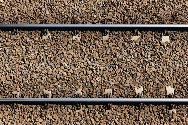 Demiryolu arka planı. Tren taşımacılığı endüstrisi. Demiryolu dokusu. Eski demiryolu ahşap kravatı. Ezilmiş taştan yapılmış denge taşları..