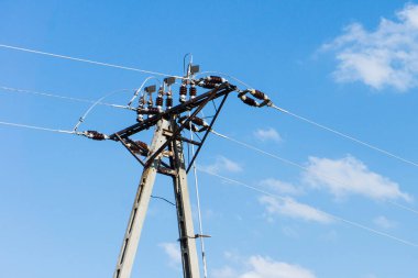 Mavi gökyüzü arka planında yüksek voltaj iletisi