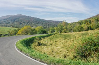 Bieszczady Ulusal Parkı. Kavisli asfalt yol. Idyllic Autumn Hills manzarası. Güney Polonya 'yı geziyorum. Yeşil çayır dağlarının arka planı. Dağ yolu yılanı