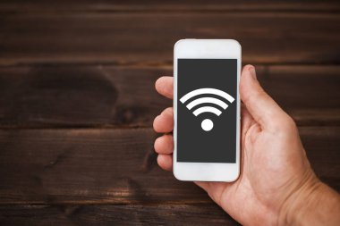 Wi-fi ikonlu akıllı telefon, ahşap arkaplan. 