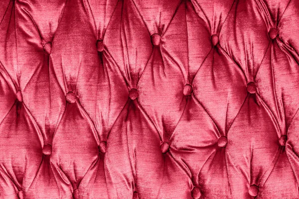 Quilted sofa background. Red color fabric texture. Luxury furniture pattern.