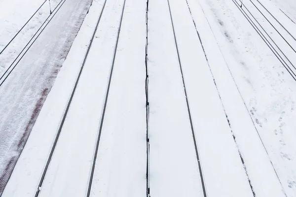 Railway top view background. Train track texture. White transportation background. Winter landscape. Snow on the railway. Icy train plaftorm. Train station covered in snow.