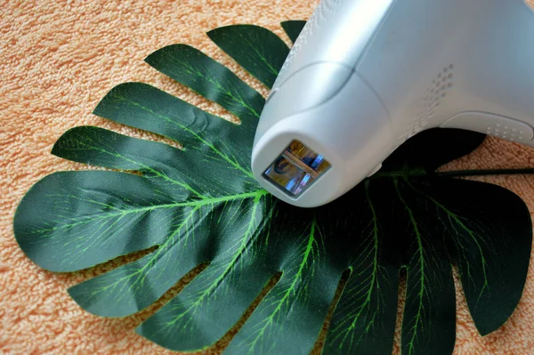 Photoepilator Encuentra Sobre Una Hoja Palma Sobre Fondo Tela Beige — Foto de Stock