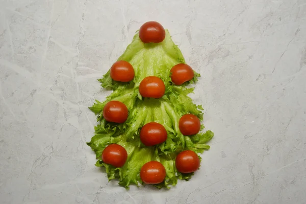 Ялинка з салату і помідорів на світлому дерев'яному фоні — стокове фото