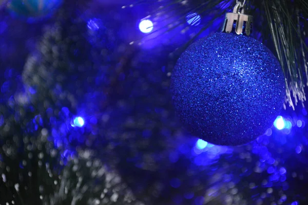 Μπλε Χριστουγεννιάτικη Μπάλα Στο Κλαδί Ελάτης Χιόνι Και Μπλε Γιρλάντα — Φωτογραφία Αρχείου