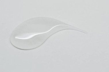 Beyaz arkaplanda şeffaf kozmetik ürünü düşüşü