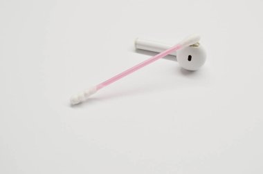 Kablosuz kulaklık ve beyaz arka planda pamuklu çubuk. Temizlik kavramı.