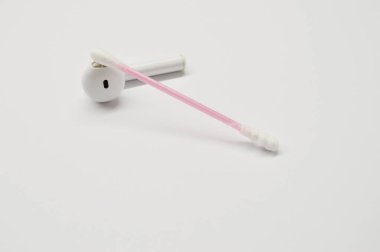 Kablosuz kulaklık ve beyaz arka planda pamuklu çubuk. Temizlik kavramı.