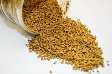 Beyaz arka planda izole edilmiş cam kavanozlardan sublimleşmiş kahve döküldü..