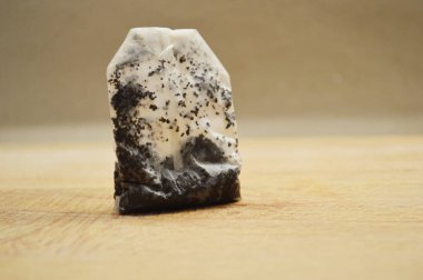 Tahta arka planda ıslak çay poşeti.