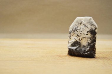 Tahta arka planda ıslak çay poşeti ve fotokopi alanı.