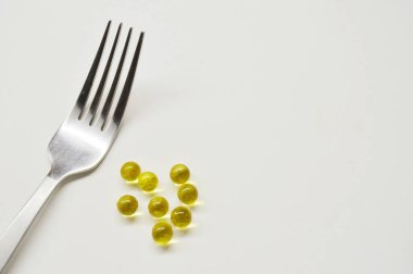 Çatal ve tablet beyaz arkaplanda. Sağlıklı yaşam tarzı yemek düzdü. İlaç gıda vitaminleri konsepti