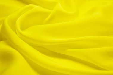 Arka plan olarak sarı tekstil deseni. Kumaştaki sarı madde dokusunu kapat. Buruşmuş kumaş dokusu