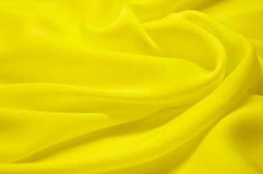 Arka plan olarak sarı tekstil deseni. Kumaştaki sarı madde dokusunu kapat. Buruşmuş kumaş dokusu