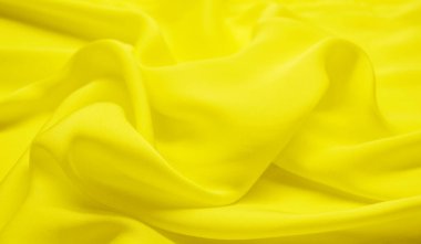 Arka plan olarak sarı tekstil deseni. Kumaştaki sarı madde dokusunu kapat. Buruşmuş kumaş dokusu