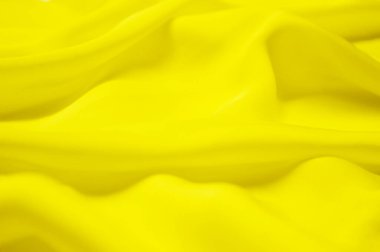 Arka plan olarak sarı tekstil deseni. Kumaştaki sarı madde dokusunu kapat. Buruşmuş kumaş dokusu