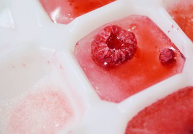 Donmuş buz küpleri ve beyaz buz küpü tepside ahududu.