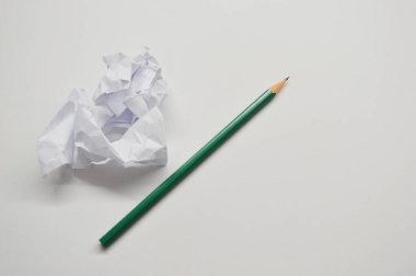 Beyaz arka planda izole edilmiş buruşmuş kağıt tomarları ve kalemler. Yazma kavramı.