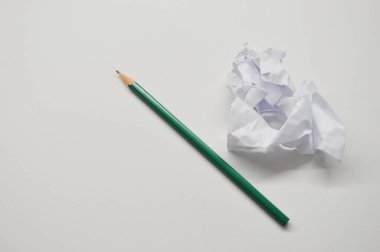 Beyaz arka planda izole edilmiş buruşmuş kağıt tomarları ve kalemler. Yazma kavramı.