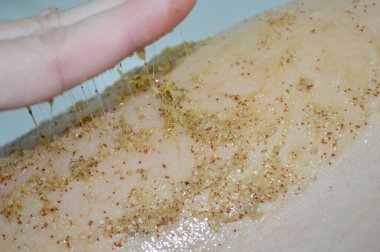 Kahve masajı fırçasıyla kadın bacaklarına yakın çekim. Kozmetik, bakım, kaplıca, güzellik ürünleri, güzellik konsepti ve bikini.