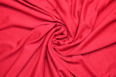 Arka plan olarak kırmızı tekstil deseni. Kumaştaki kırmızı madde dokusuna yaklaş. Buruşmuş kumaş dokusu