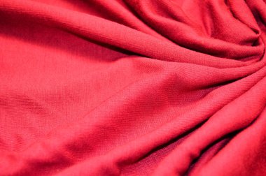 Arka plan olarak kırmızı tekstil deseni. Kumaştaki kırmızı madde dokusuna yaklaş. Buruşmuş kumaş dokusu