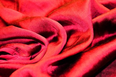 Arka plan olarak kırmızı tekstil deseni. Kumaştaki kırmızı madde dokusuna yaklaş. Buruşmuş kumaş dokusu