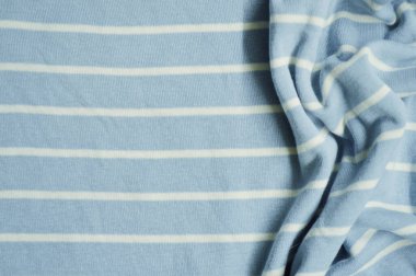 Arka plan olarak beyaz ince çizgili tekstil desenli mavi. Mavi 'ye beyaz çizgili kumaş kumaş kumaşı ile yaklaş. Buruşmuş kumaş dokusu