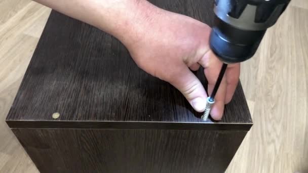 Mens Gebruikt Een Schroevendraaier Schroeven Een Donker Houten Bord Aan — Stockvideo