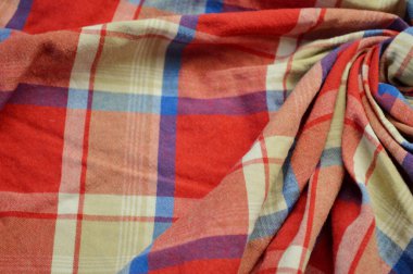 Arka plan olarak kırmızı kareli tekstil. Kumaştaki kırmızı kareli kumaş dokusuna yaklaş. Buruşmuş kumaş dokusu