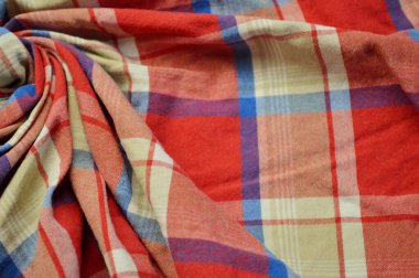 Arka plan olarak kırmızı kareli tekstil. Kumaştaki kırmızı kareli kumaş dokusuna yaklaş. Buruşmuş kumaş dokusu