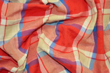 Arka plan olarak kırmızı kareli tekstil. Kumaştaki kırmızı kareli kumaş dokusuna yaklaş. Buruşmuş kumaş dokusu