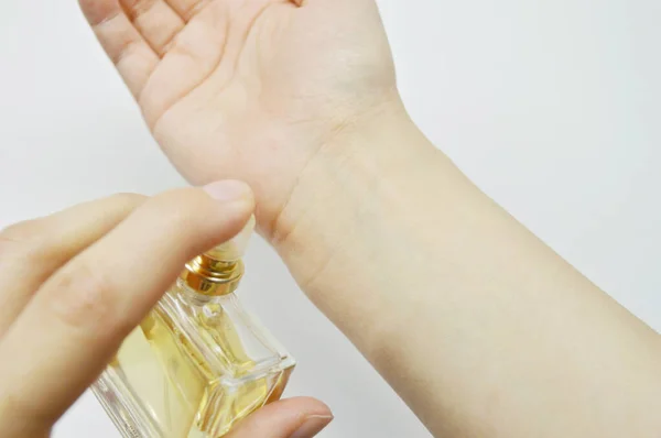 Kobiety Posypują Perfumy Szklaną Butelką Jej Ręce Białym Tle — Zdjęcie stockowe