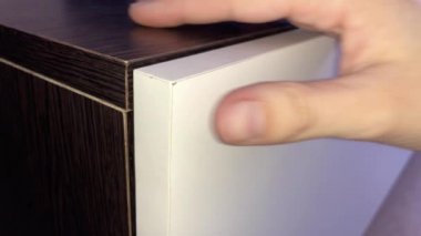 Kadın bir düğmeye basarak gardırop kapısını açar..