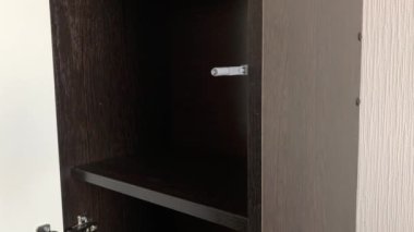 Kadın bir düğmeye basarak dolabın kapısını kapatıyor..