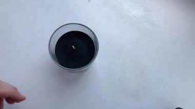 Kadın, kokulu mumu çakmakla yakar..