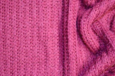 Arka plan olarak pembe örülmüş tekstil deseni. Pembe örülmüş kumaş dokusuna yakın çekim yap. Buruşmuş kumaş dokusu