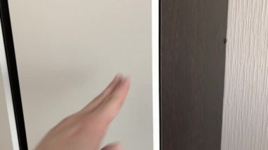 Kadın bir düğmeye basarak gardırop kapısını açar..