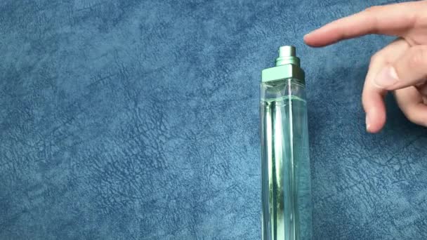 Female Hand Sprinkles Perfume Clicking Them Forefinger Blue Background — Stock Video