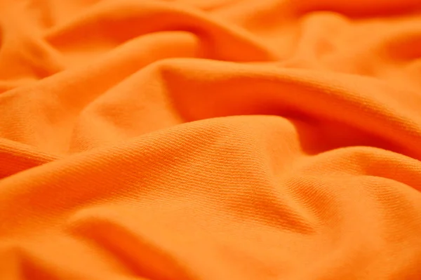 背景としてオレンジのテキスタイルパターン 生地にオレンジ素材の質感を閉じます 縮れた生地の質感 — ストック写真