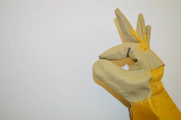 Hand Beige Und Gelb Arbeitstuchhandschuh Zeigt Zeichen Vor Weißem Wandhintergrund — Stockfoto